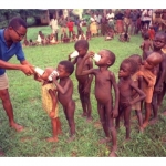 A-Biafran-doctor-hands-out-cups-containing-the-daily-ration-of-powdered-milk-to-a-line-of-children-at-a-refugee-camp-in-Anwa-Biafra-Aug.-5-1968