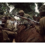 men-wear-camouflage-and-hold-their-rifles-as-they-move-through-the-wilderness-during-Nigerias-Biafran-civil-war